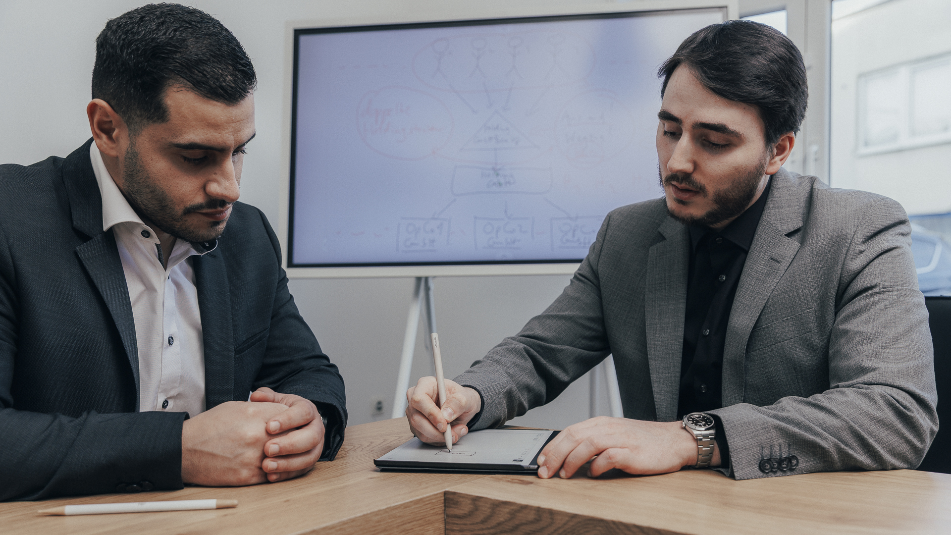 Zwei Steuerberater für E Commerce machen sich Notizen auf einem Tablet