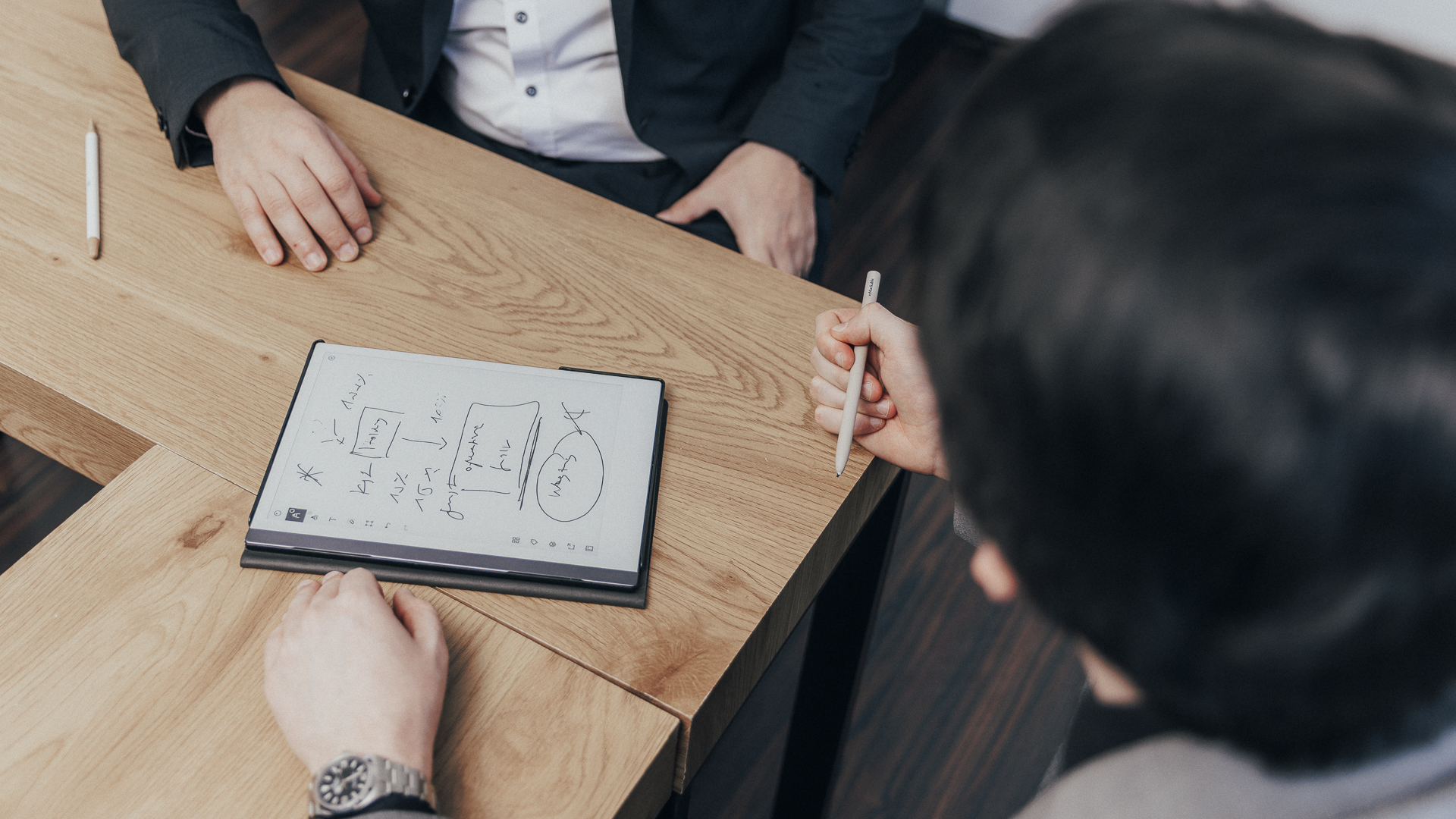 Ein Tablet, auf dem sich zwei Steuerberater für Heilberufe Notizen machen